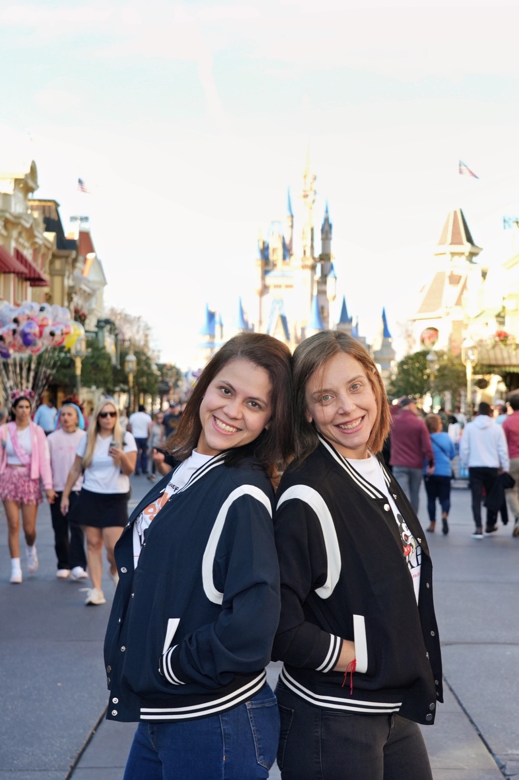 María Virginia y Samaj espalda con espalda en Main Street de Magic Kingdom con el castillo de Cenicienta al fondo